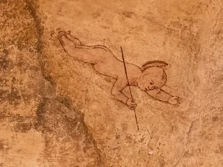 Dettaglio della lunetta affrescata da Gianfrancesco da Tolmezzo con la raffigurazione di Gesù Cristo come bambino in volo verso la Vergine Maria. Il bambino è ritratto di profilo mentre scende dal cielo con le braccia rivolte in avanti. Sulla mano destra regge una verga.