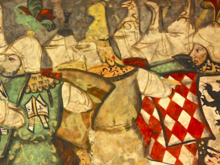 Un affresco medievale recuperato che raffigura un gruppo di cavalieri armati a cavallo o in processione. I cavalieri indossano elmi bianchi e vesti ornate; uno ha una sopravveste a losanghe rosse e bianche con uno stemma araldico nero. La parete è di intonaco chiaro con bordi irregolari. La scena racconta l'assedio di Pamplona.