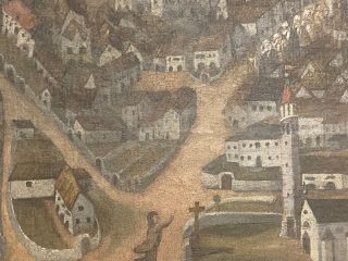 Un dettaglio di un'opera che mostra un fitto insediamento collinare con edifici e strade. In primo piano, al centro, una singola figura con una veste scura è raffigurata in ginocchio. Le mani sono sollevate e tese, come in preghiera o in supplica, rivolte verso una semplice croce di legno piantata nel terreno sulla destra. La pittura è consumata, riflettendo la sua età. L'affresco è un'importante testimonianza storica del villaggio di Cimolais durante l'incendio del 1913 e fa parte delle opere EX VOTO del Museo Diocesiano.