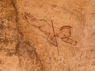 Dettaglio della lunetta affrescata da Gianfrancesco da Tolmezzo con la raffigurazione di Gesù Cristo come bambino in volo verso la Vergine Maria. Il bambino è ritratto di profilo mentre scende dal cielo con le braccia rivolte in avanti. Sulla mano destra regge una verga.
